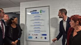 Un groupe de personnes (Dont Madame La Maire) se tient à côté d’une plaque murale commémorative. La plaque indique l’inauguration du Complexe Sportif Philippe Gatien le samedi 28 septembre 2024. Elle mentionne les noms et fonctions de plusieurs personnalités présentes lors de l’événement, dont des représentants de la préfecture, de la région Hauts-de-France, du département du Nord, de la Ligue de Football, ainsi que des élus locaux de Bruay-sur-l’Escaut. Plusieurs logos d’organismes partenaires figurent en bas de la plaque.