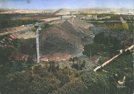 1957. Vue aérienne sur les terrils du site Rousseau. Dans le fond se dressent les terrils de La Grange et de Thiers. Au premier plan, en prolongement de l’Allée des Noisetiers, ce chemin mène à l’Etoile de Cernay.