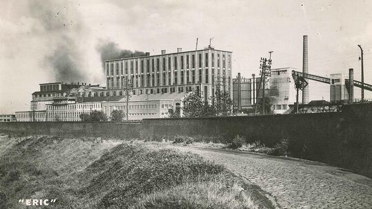 Vers 1960. Après avoir franchi l’Escaut, la route pavée mène à Onnaing. A gauche, en contre-bas, le Jard se dirige lentement vers Escautpont.
