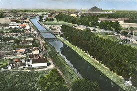 Vue aérienne du canal vers 1950. Ce paysage n’existe plus, tout a été bouleversé. Le lit de l’Escaut a été déplacé lors de sa mise au grand gabarit et a été comblé.