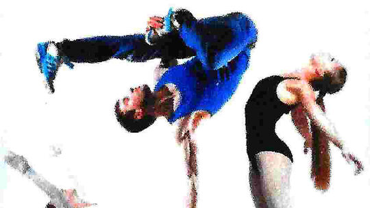 L’image montre deux individus en pleine performance acrobatique ou chorégraphique. L’un, vêtu de bleu, est en l’air, semblant effectuer un saut ou une figure acrobatique. L’autre, habillé en noir, est incliné vers l’arrière ou en position d’étirement. Le fond blanc met en valeur les mouvements dynamiques des deux personnes.