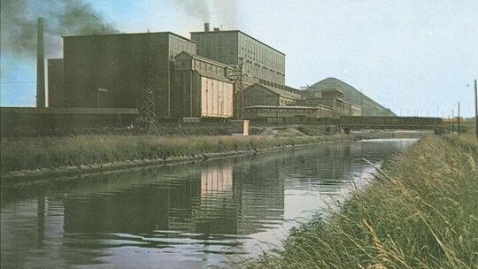 Cliché datant de 1950.
Derrière la centrale se trouvent les fours à coke où s’effectue la carbonisation de la houille par la chaleur et à l’abri de l’air pour en extraire les produits solides (coke), liquides (goudrons, benzols) et gazeux (hydrogène, méthane).
