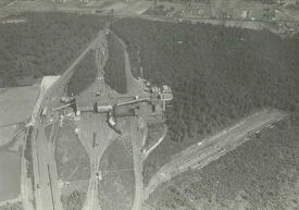 Vue aérienne datant d’août 1949. Implanté en la forêt de Raismes en 1939 par la Compagnie des Mines d’Anzin, l’établissement Rousseau est d’abord un lavoir capable de traiter 500 tonnes par heure de charbons bruts arrivant par wagons des sièges La Grange, Sabatier (Raismes), Ledoux (Condé) et Agache (Fenain).