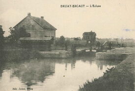 La vieille écluse et la maison éclusière. Manœuvrée manuellement, elle ne permet le passage que d’une seule péniche à la fois. C’est un travail pénible car il faut faire tourner une grosse manivelle pour ouvrir et fermer les portes de l’écluse.